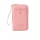 Pink leather travel wallet with "Passport" embossed, featuring a wrist strap and airplane icon. Ideal for organizing travel documents securely.