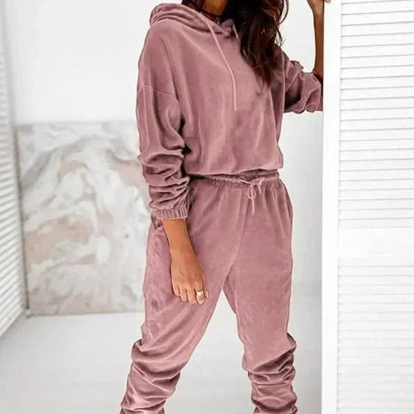 Women's pink velour sweatshirt set, featuring a hooded top and drawstring pants. Comfortable loungewear, perfect for casual and cozy fashion.