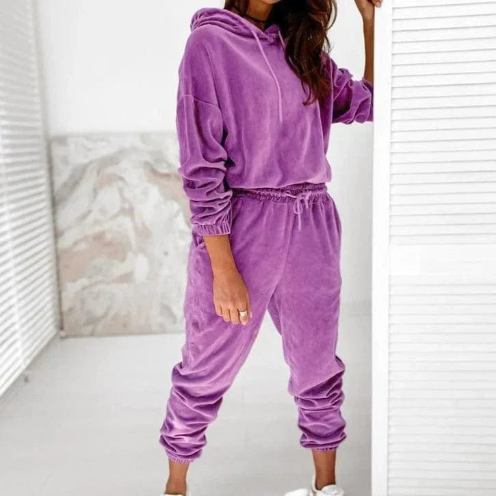 Woman wearing a stylish purple velour sweatshirt and jogger set, perfect for casual wear. Comfortable loungewear fashion, cozy hoodie outfit.