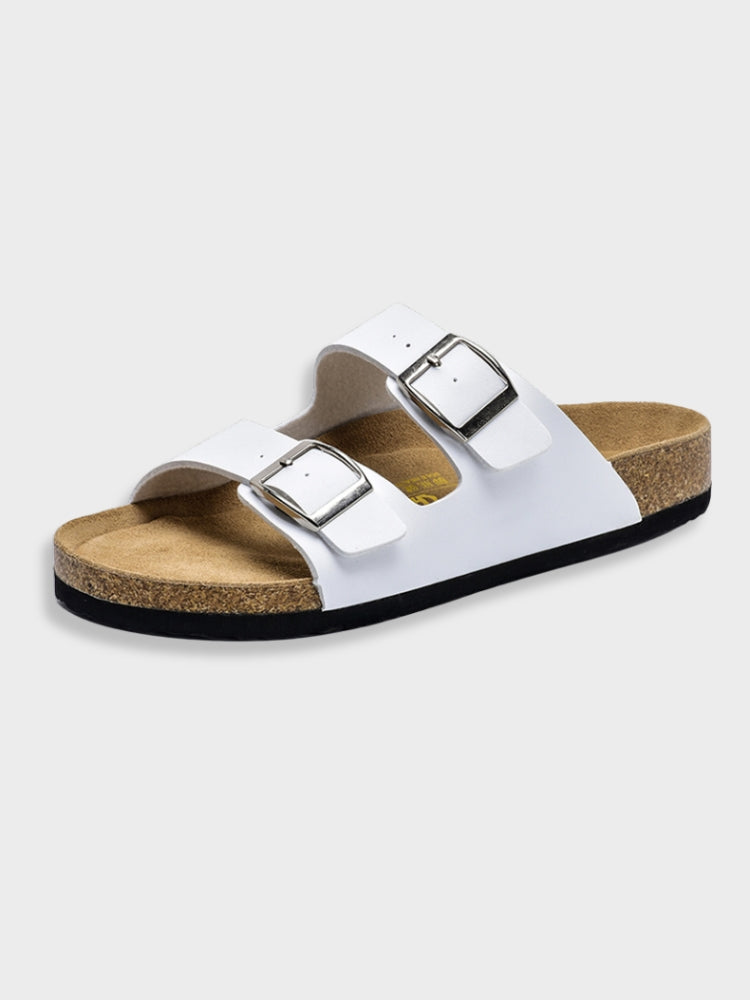 White two-strap sandal with cork footbed and silver buckles, isolated on white background. Comfortable summer footwear, casual slip-on design.