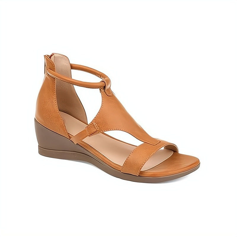 Women's tan leather wedge sandal with open toe and ankle strap, featuring a comfortable low heel. Perfect for casual summer fashion.