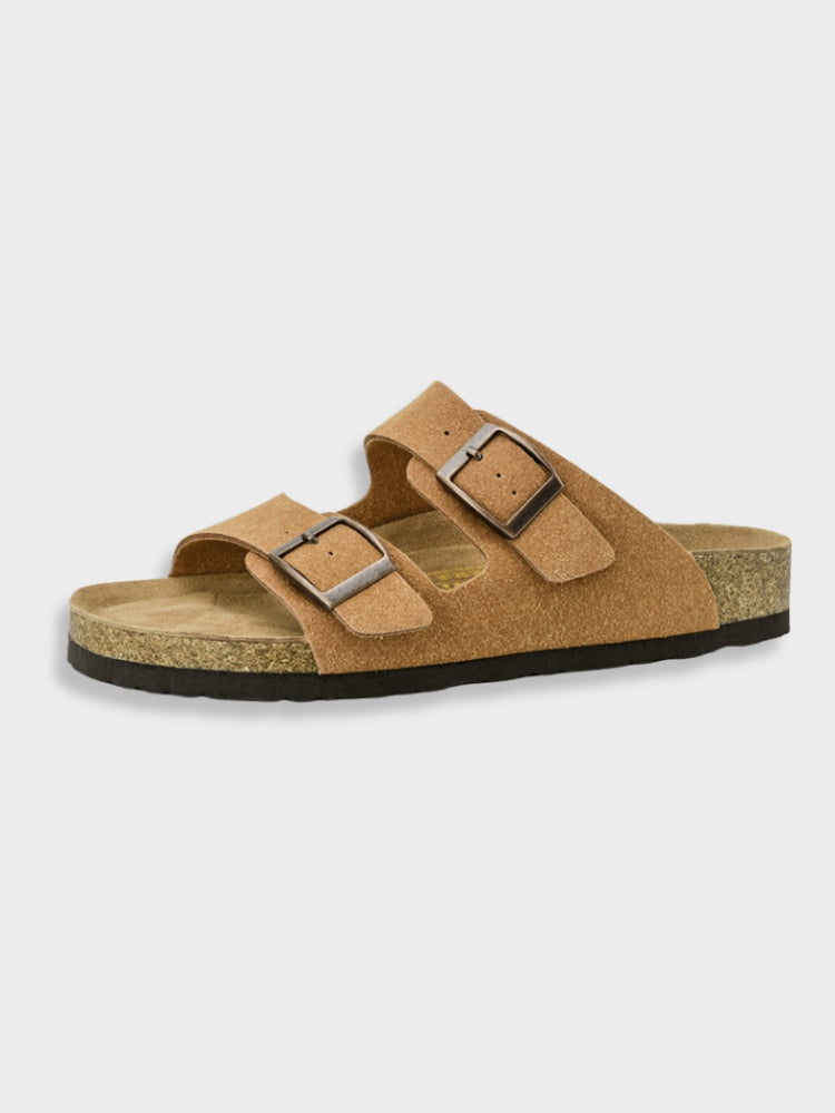 Tan suede sandal with dual adjustable straps and cork footbed, featuring a black rubber sole. Comfortable, stylish footwear for casual wear.