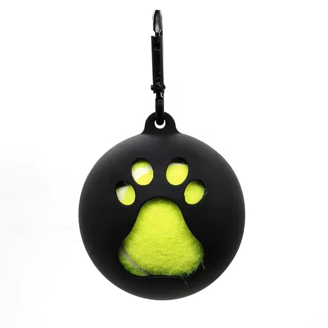 Black silicone dog ball holder with paw-shaped cutout, featuring a bright yellow tennis ball inside. Pet accessory, durable, portable design.